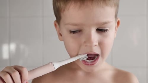 Young Boy Brushing Teeth in Bathroom Close Up