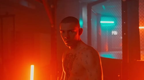 Intense Tattooed Man Stares in Dramatic Lighting