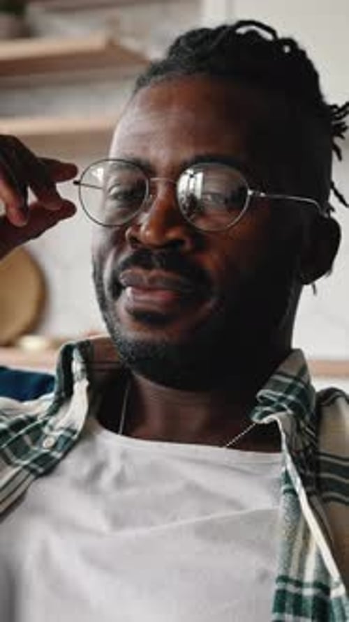 Overwork Concept Müder afroamerikanischer Mann fühlt sich müde, nimmt die Brille ab und reibt sich die Augen