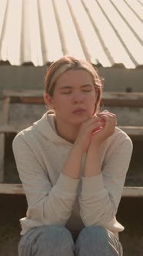 Pensive Woman in Deep Reflection on Rustic Stadium Bleachers