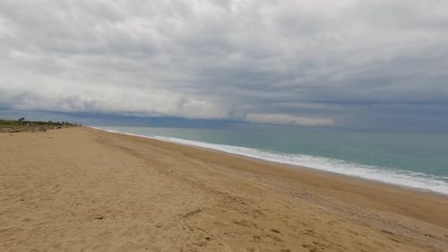 Coarse sand beach sea wave in slow motion at 120fps 4k cloudy day turquoise water single sea waves B