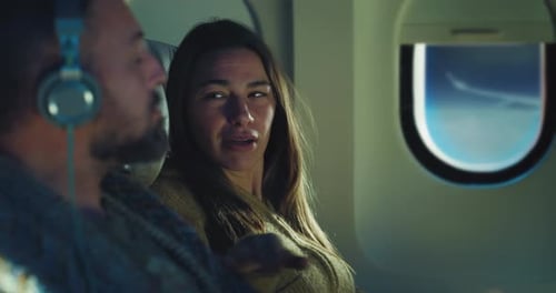 Cinematic shot of young woman waking up her husband to show something outside while he napping