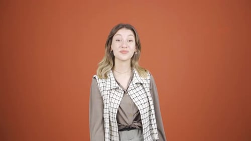 Woman Gives Thumbs Up on Orange Background