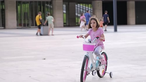 Cycling City Park Recreation Excited Little Girl Rides a Bicycle The Child's Feet are Pedaling A