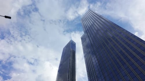 Bottom Up View of Large Glass Modern Skyscrapers Against a Blue Cloudy Sky Workplaces and Business