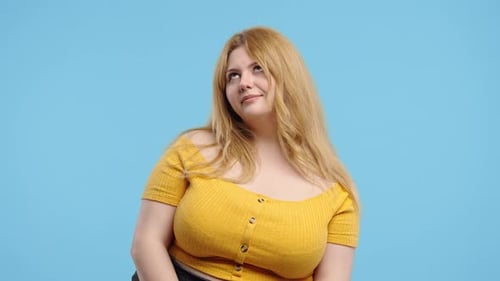 Woman Posing in Yellow Shirt on Blue Background