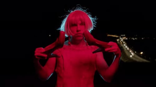 Model Holding High Heels at Night in City