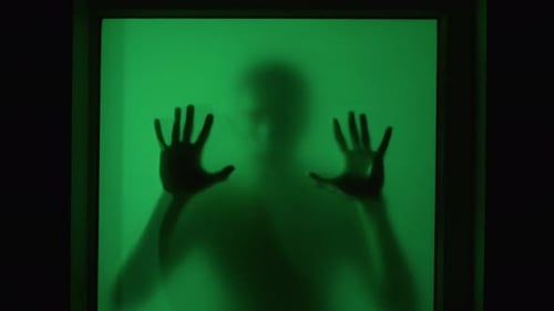 Horror Scene Silhouette of Man on Other Side of Window Ominously Touches the Glass and Looks and