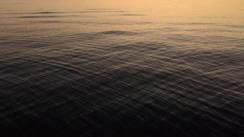 Ruhiges Meereswellen mit Reflexion des Sonnenuntergangslichts auf der Oberfläche. - Statische Aufnahme