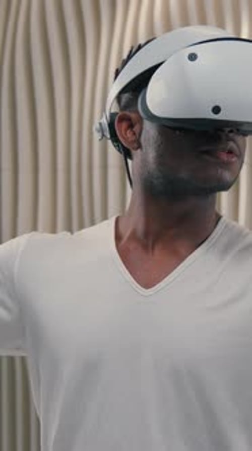Man Using VR Headset and Controllers in Modern Setting