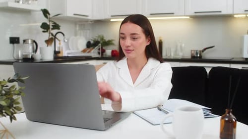 Young Woman Closes Laptop Looks at Camera Light Smile Breathes Relief End of Workday Calm Rest Time