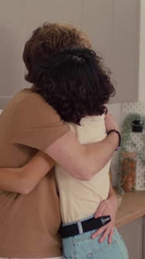 Affectionate Couple Hugging and Kissing in Kitchen