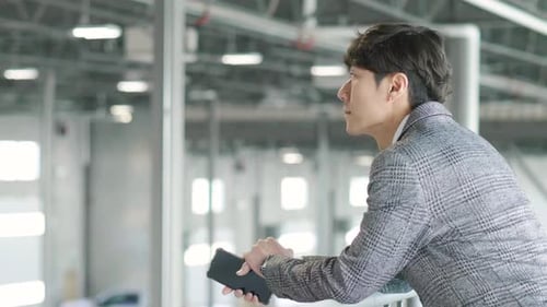 Male Architect With Smart Phone In Empty Warehouse