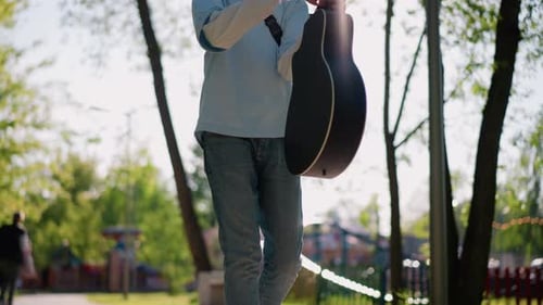 Male Guitarist Outdoors Casual Musician on Sunny Day Relaxed Young Man with Acoustic Guitar in Park
