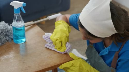 Woman Cleaning a Wooden Table in a Home