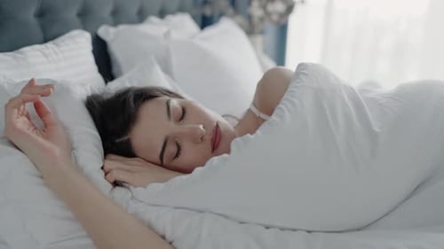 Woman Sleeping Peacefully in White Bed