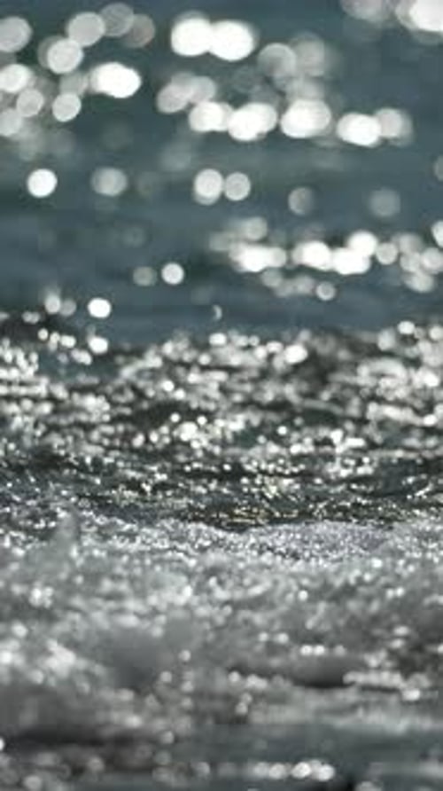 Small waves splashing on the sandy beach shore