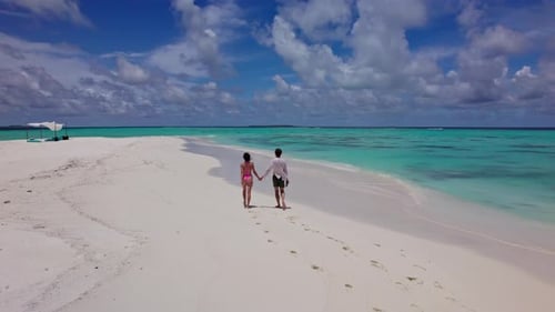 Couple Walking on White Sand in the Maldives