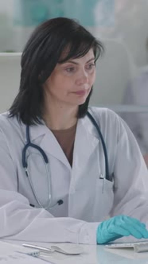 Portrait of Middle-Aged Female Doctor Working on Computer in Hospital