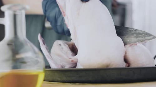 Gloved Person Cutting Duck with Knife