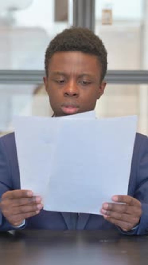 vertical video of African Businessman Reading Documents in Office