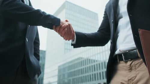 Businessmen Handshake in front of Modern Office Building