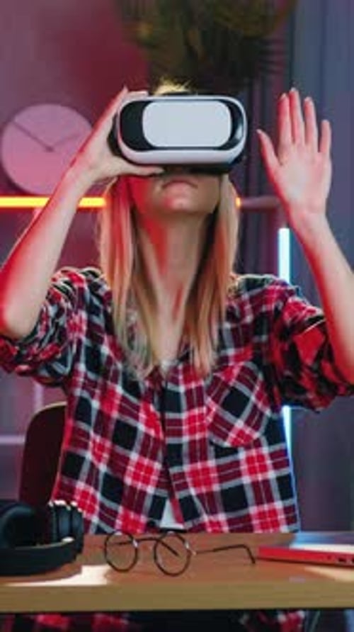 Woman Wearing VR Headset Interacts with Technology at Desk