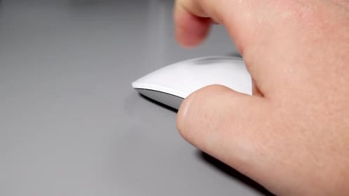 Man using a white computer mouse on grey table desk