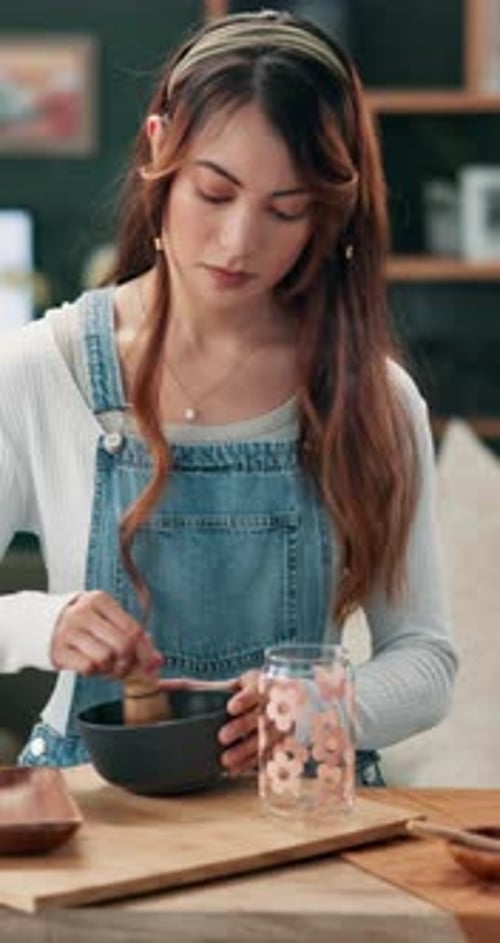 Young Woman Mixing Drink with Whisk Indoors
