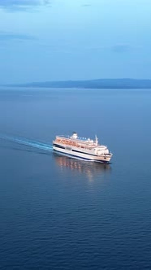 Aerial, drone view of a white boat moving on the the Adriatic sea in Croatia. Vertical