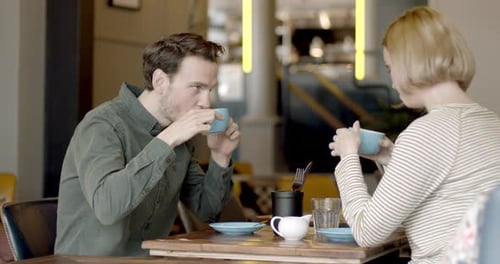 Young Adult couple having a good time together in cafe restaurant and drinking coffee