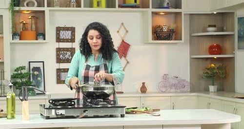 Woman Cooks Vegetables in a Kitchen