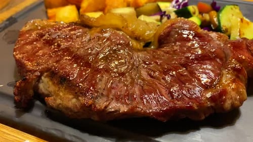 Juicy beef filet steak with vegetables and cubed potatoes on a plate, restaurant food, 4K shot
