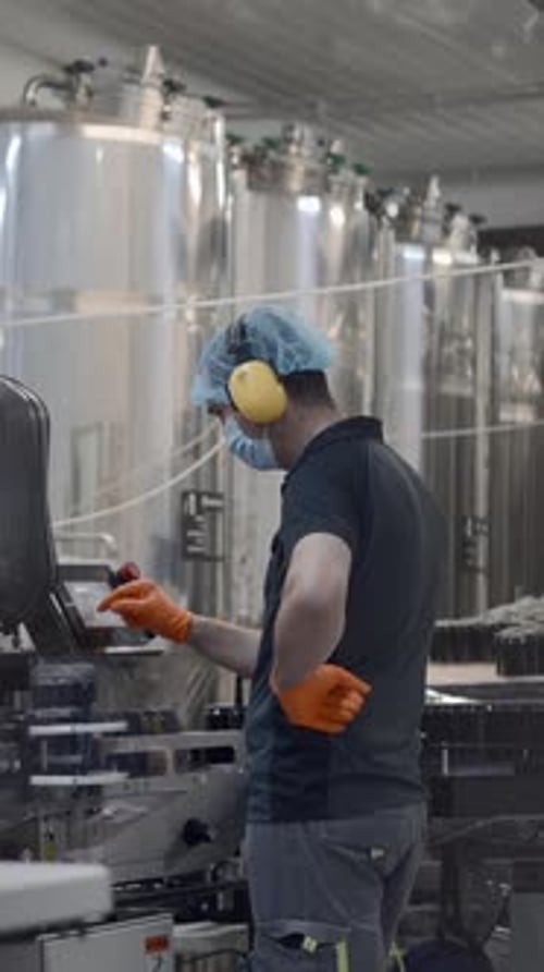 Man Works with Automated Machinery in Bright Factory