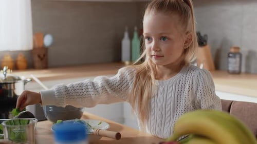 Girl Chopping Vegetables on Cutting Board in Kitchen