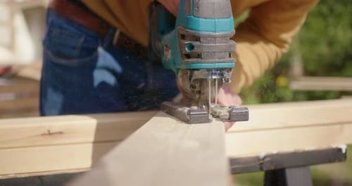 Woodworking Jigsaw Cuts Lumber in Rural Setting