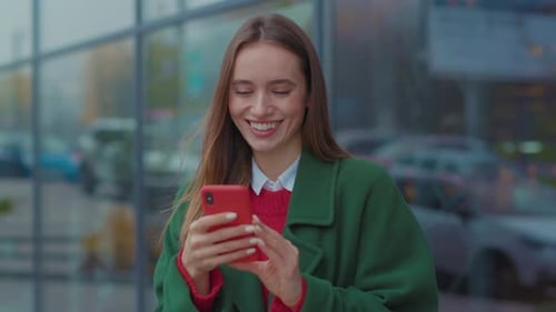 Smiling Young Woman Uses Phone in the City Center on Christmas Time Happy Internet Mobile Adult