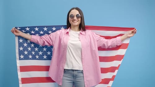 Young Woman with American Flag and Sunglasses Smiling