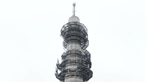 Aerial low angle ascending shot of a bleak industrial concrete television and radio link tower in Pa
