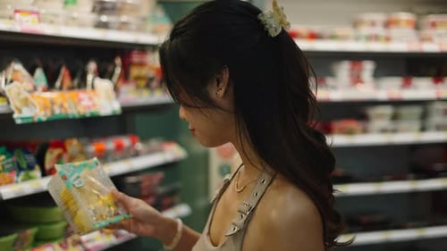 Customer Reading Nutrition Facts on Packaged Food in Grocery Store