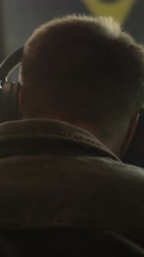 Young Man Puts On Blue Headphones Inside