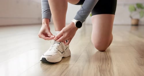 Athlete, hands and tie shoes in gym to start workout, training or exercise
