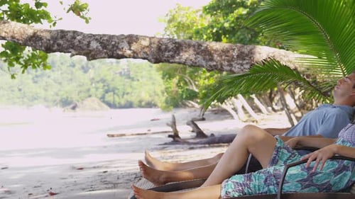 Couple Laying on Chairs at Beach. on Red Epic for High