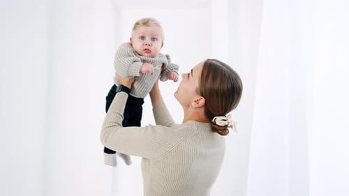 Happy Mother Playing with her Infant Baby