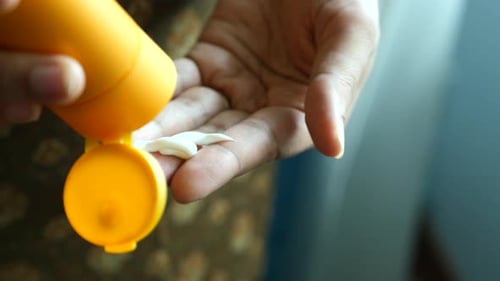 Close Up of Person Hand Using Sunscreen Cream Outdoor