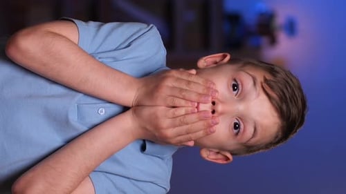 Surprised Young Boy Covers Mouth with Hands