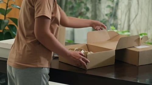 Woman Opens Box with Pair of Cream Sandals