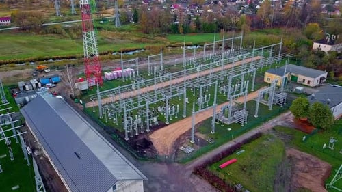 Aerial drone forward moving shot taken over a high voltage power distribution substation at daytime.