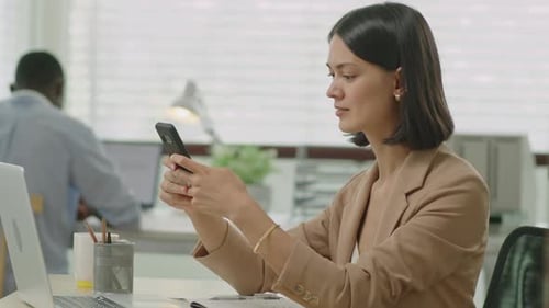 Businesswoman Using Smartphone in Office