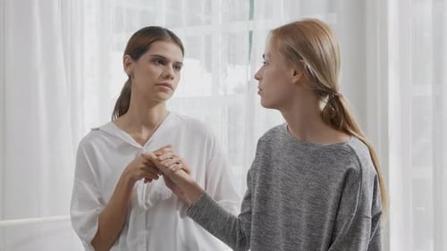 Young caucasian woman depressed while friends encourage in the bedroom at home.